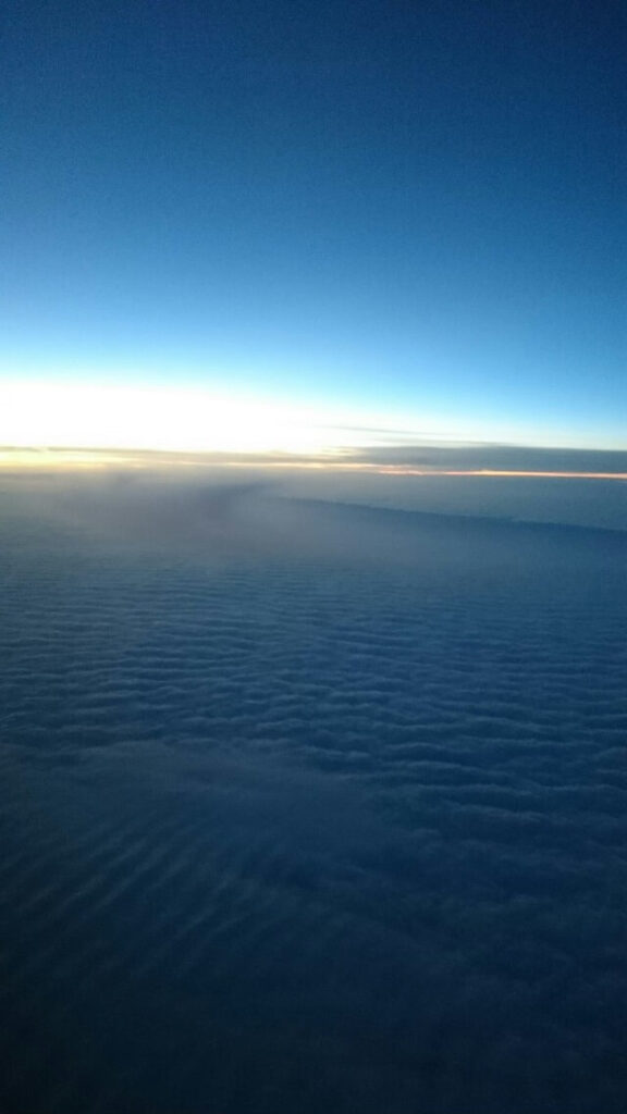 飛行機から見える夕日を受けた雲海